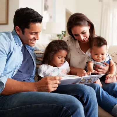 famille avec de jeunes enfants qui regarde un livre