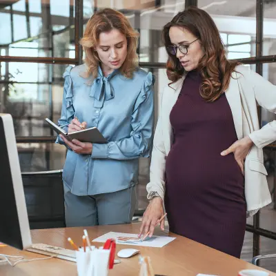 Femme enceinte avec sa collègue dans un bureau